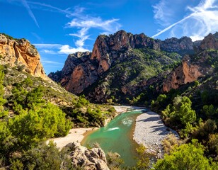 Scenic mountain range and turquoise river flowing through a lush green valley under a blue sky
