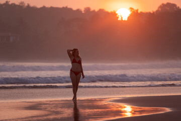 Fototapeta premium Young Woman Walking Along Talalla Beach at Sunset, Sri Lanka