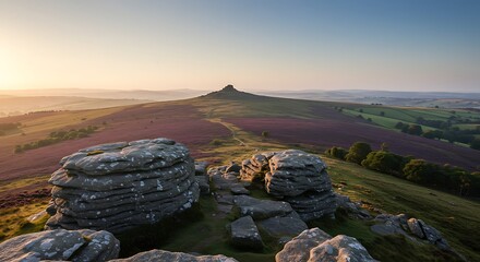 Scenic mountain ridge view at sunrise, showcasing rocks, flora, and a long vista under a clear sky