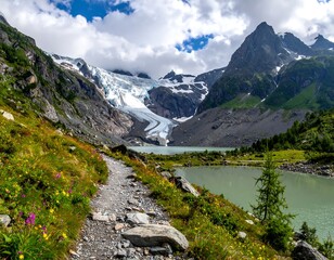 Scenic mountain trail leading to glacial lake with vibrant wildflowers under a cloudy sky