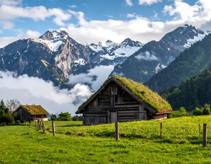 Obraz premium Scenic vista featuring traditional cabins with grassy roofs set against a backdrop of snow-capped mountains