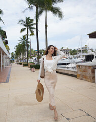 Young woman with luggage walks near the boat marina