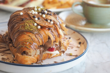 Croissant filled with cream and chocolate on a plate