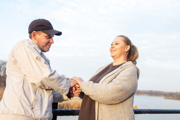 Casual middle-aged woman enjoys a coffee break while walking in park.