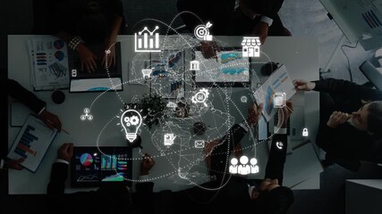 A high-angle view of a business meeting featuring a diverse team discussing strategies with digital graphics overlay, encapsulating technology and data insights. Raster - Powered by Adobe