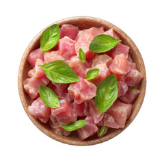 Overhead view of cubed raw meat in a wooden bowl garnished with fresh basil leaves