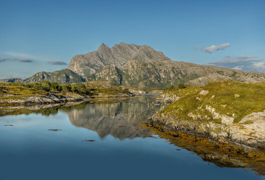 Tranquil lake mirroring the mountain behind in the north of Norway
