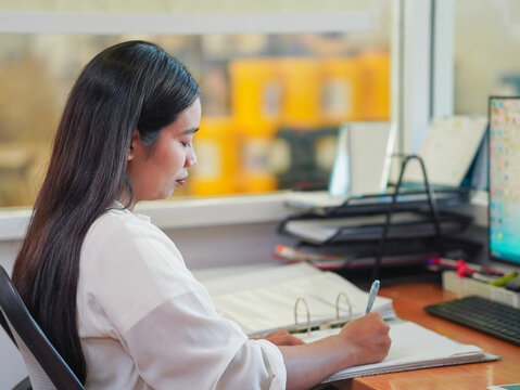 Businesswoman using phone laptop browsing internet goal planning new beginnings remote work workplace. Young professionals meeting collaboration brainstorming in office. Female leadership use AI chat