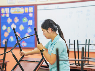 Asian teacher woman cleaning classroom at school. People clean housework college. Back to school. Education knowledge learning. Chore of student 