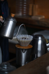 Pouring water into a long-spouted kettle to make pour-over coffee