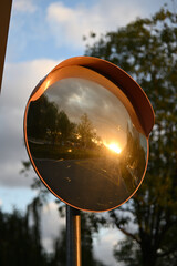 Roadside reflector reflecting the orange sunset