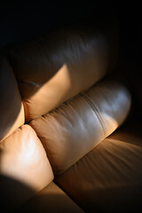 A relaxing brown leather sofa bathed in the evening sunlight.
