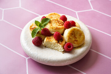 cottage cheese pancakes with raspberries and mint on pink background
