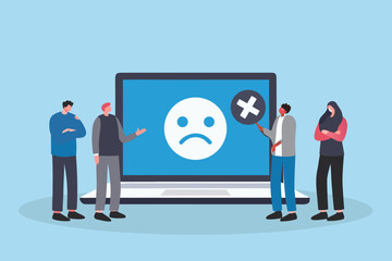 Diverse group of people looking at a laptop screen displaying a sad face emoji and a cross symbol indicating a problem