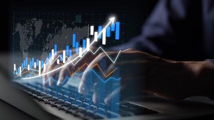 A close-up view of hands on a laptop keyboard, overlaid with dynamic financial graphs and charts, showcasing stock market analysis in a modern workspace. Copula