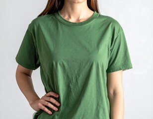 Torso of a person in a plain green shirt, posed indoors with natural light