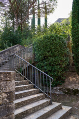 An old stone staircase leads upward through lush greenery in Gerona, Spain