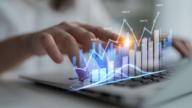 A hand interacting with a laptop showcasing graphical data analysis. The visual elements illustrate growth, trends, and metrics essential for business decisions. Scalp - Powered by Adobe