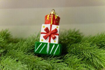 A charming Christmas setup featuring a Santa Claus figurine surrounded by small festive decorations and wrapped presents. The scene highlights warm holiday cheer with miniature ornaments, gift boxes, 