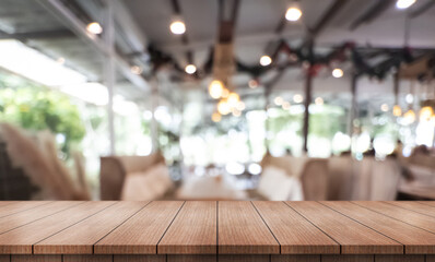 Empty wooden table top with lights bokeh on blur restaurant background.