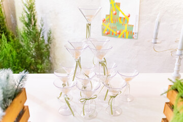 A charming Christmas setup featuring a Santa Claus figurine surrounded by small festive decorations and wrapped presents. The scene highlights warm holiday cheer with miniature ornaments, gift boxes, 