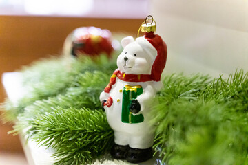 A charming Christmas setup featuring a Santa Claus figurine surrounded by small festive decorations and wrapped presents. The scene highlights warm holiday cheer with miniature ornaments, gift boxes, 