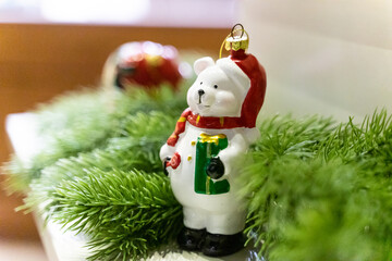 A charming Christmas setup featuring a Santa Claus figurine surrounded by small festive decorations and wrapped presents. The scene highlights warm holiday cheer with miniature ornaments, gift boxes, 