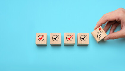 Success building concept with hand stacking wooden blocks step by step, showing checkmarks and progress icons, representing achievement, planning, strategy, and long-term development. © Sutthiphong