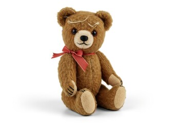 Fototapeta premium Classic brown plush bear toy with a red ribbon sits against a white background