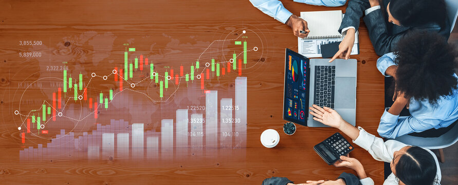 A diverse business team collaborates on financial analysis using charts and a laptop. The modern office setting promotes teamwork and strategic planning. Scalp - Powered by Adobe