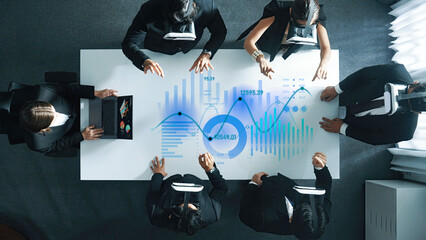 A business team engages in a collaborative meeting using virtual reality headsets, analyzing data on a digital screen in a modern office environment. Scalp