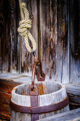 Vintage wooden well with a rope and bucket, displaying rustic charm and craftsmanship in a serene outdoor setting during daylight