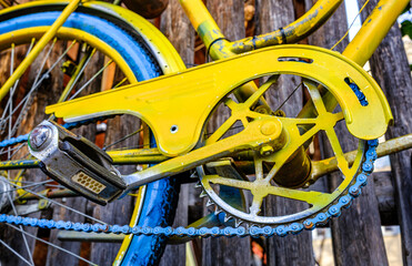Vintage blue bicycle leaning against a colorful wall in bright sunlight during afternoon hours in an urban setting