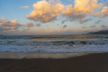 Beautiful sunset over the ocean with dramatic clouds and  wave.