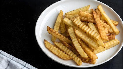 Overhead view of finger fries on plate positioned right.