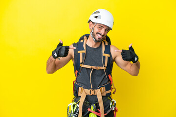 Young caucasian rock climber man isolated on yellow background proud and self-satisfied