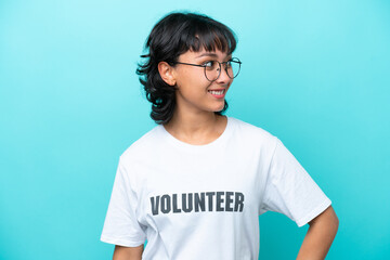 Fototapeta premium Young volunteer Argentinian woman isolated on blue background looking to the side and smiling