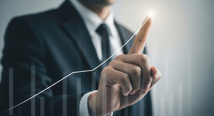 Businessman pointing at upward trending graph, financial success concept.