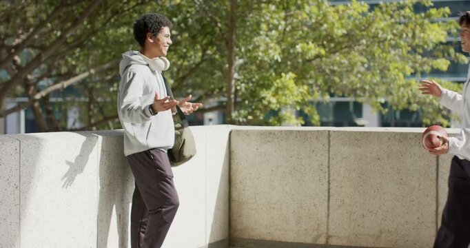 Clapping at plaza railing, Diverse male friends exchanging handshake after football arrival