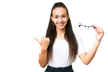 Young Arabian woman holding glasses over isolated chroma key background pointing to the side to present a product
