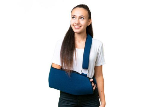 Young Arabian woman with broken arm and wearing a sling over isolated chroma key background thinking an idea while looking up