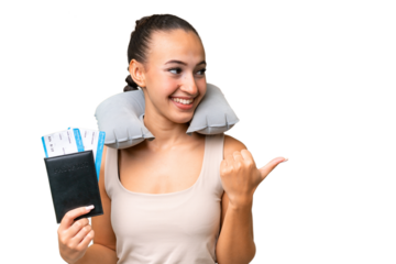 Young Arab woman with Inflatable Travel Pillow over isolated background pointing to the side to present a product