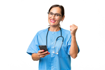 Middle-aged nurse woman over isolated background with phone in victory position