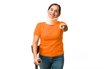 Middle-aged caucasian woman wearing neck brace over isolated background pointing front with happy expression