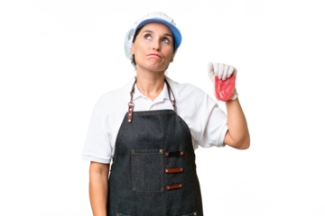 Butcher woman wearing an apron and serving fresh cut meat over isolated background and looking up