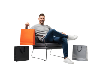 young caucasian man in a grey cashmere sweater and jeans, relaxing in a charcoal armchair, holding an orange luxury shopping bag against a high-key white studio background. concept of luxury consumer