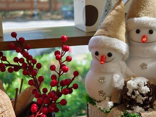 Christmas decoration with snowman and red berries on the window sill.