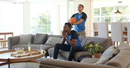 Diverse friends pausing basketball game on sofa, tensing then mimicking free throw and celebrating - Powered by Adobe