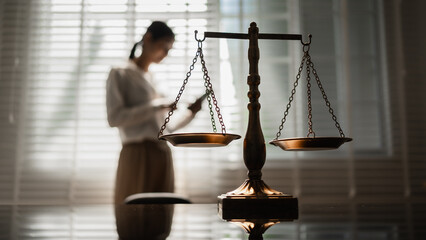 The scales of justice stand in focus while a woman seeks counsel, symbolizing the legal protection of women's rights, gender equality, safety from domestic violence, and the pursuit of fair justice.