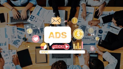 A diverse business team engages in collaboration to develop advertising strategies. Modern office space showcases laptops, charts, and digital elements, reinforcing data-driven decisions. Raster